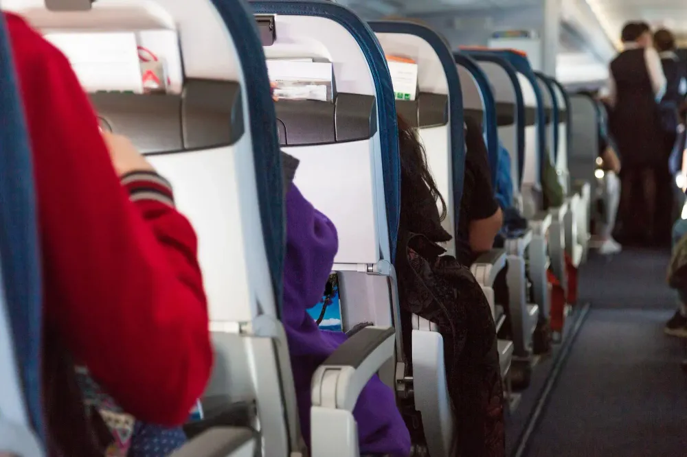 View down the center aisle of a plane as people board